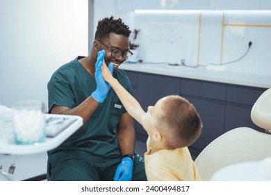 Child visit dentist. Laughing Little boy have five to dentist at dental clinic. Child in stomatological cabinet with dentists. Little boy at regular dental check-up. Little boy at the dentist - Powered by Shutterstock