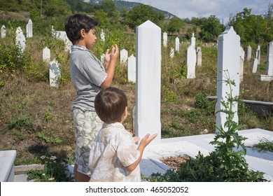 Child Visiting Grave In Cemetery