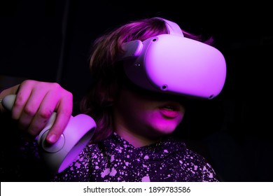 Child With VR Head Set. White New Generation Gaming Headset  Device For Entertainment And Sport With Purple Sparkling Futuristic Lights. 