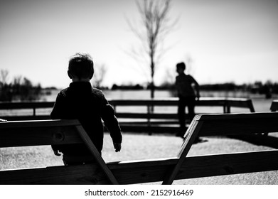 Child Waiting Along Fence For Next Round Of Gaga Ball In A School Playground.