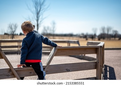 Child Waiting Along Fence For Next Round Of Gaga Ball In A School Playground.