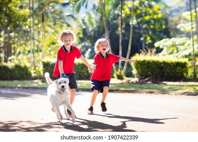 Child Walking Dog. Kid Playing With Cute Puppy. Little Boy Running With His Pet. Children Play In Suburban Neighborhood Street. Animal Friends. Friendship And Love.