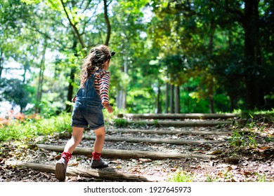 A Child Walking On The Steps Of The Forest