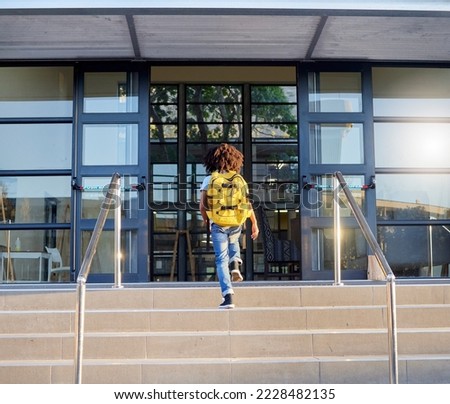 Child, walking and school entrance for education, learning or childhood development at academy building. Kid having a walk up the steps ready for back to school morning with backpack for knowledge