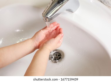 Child Washing hands under the faucet with water. Hygiene concept.