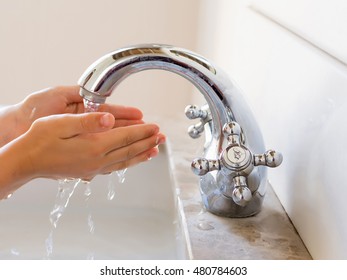 Child Washing Hands Under The Running Water Tap