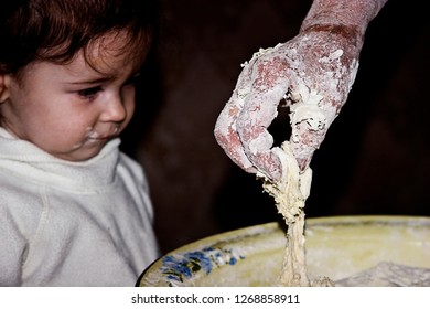 The Child Watches As The Grandmother Bakes Bread