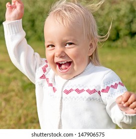 Child Waving His Arms While Screaming And Smiling