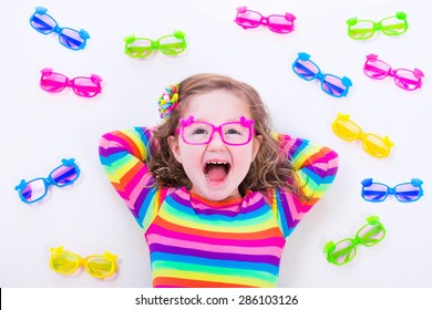 Child Wearing Eye Glasses. Eye Wear For Kids. Little Girl Choosing Spectacles. Lens And Colorful Frame Choice For Children. Vision And Sight Control At Optician Shop. Smart Preschooler With Eyeglasses