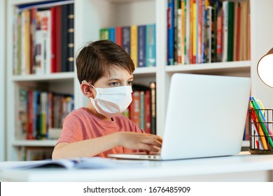 Child Wearing Face Mask Learning At Home. Young Student Wearing Surgical Mask Doing His Homework.