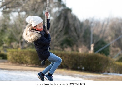 A Child Wearing A Mask Playing In A Winter Park