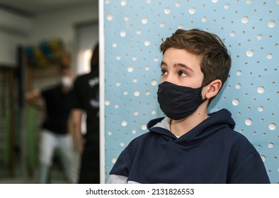 A Child Wearing A Protective Mask Waiting For His Turn In A Physiotherapy Clinic.