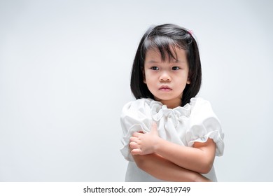 Child In White Shirt Sits Scratching Her Arm Due To Itching On Skin.