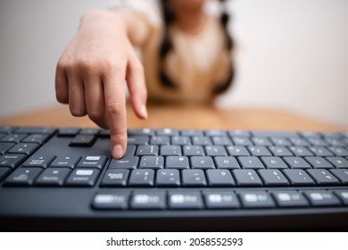 A Child Who Presses The Enter Key On A Computer Keyboard