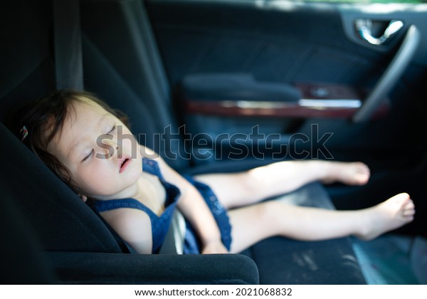 A\
child who is tired of playing and sleeps in the\
car