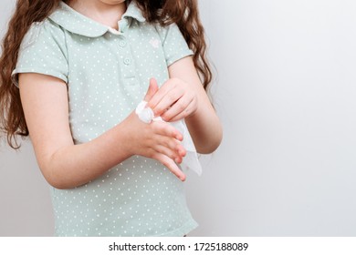 The Child Wipes Her Hands Wet Antibacterial Wipe. The Importance Of Personal Hygiene. The Fight Against The Virus.