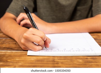 child wiriting with a pen at school
