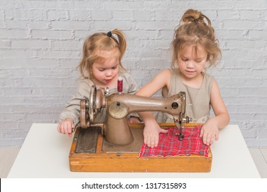 Child Working Behind Vintage Sewing Machine, On Brick Wall Background