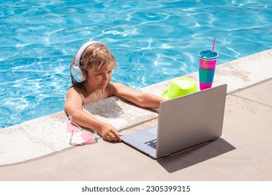 Child working with laptop on summer vacation holidays. Little freelancer using computer, remote working in swimming pool. Summer online technology.