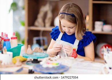 Child working on pottery wheel. Kids arts and crafts class in workshop. Little girl creating cup and bowl of clay. Creative activity in school. - Powered by Shutterstock