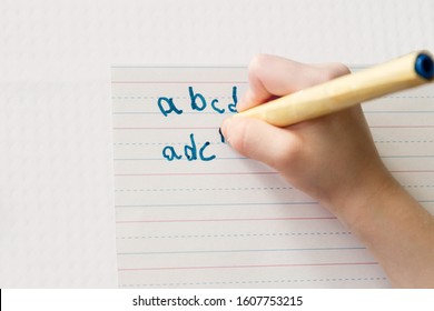 Child writes the alphabet with pencil but mixes up b and d; child practices letter formation but reverses b and d