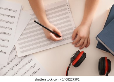 Child Writing Music Notes At Table, Top View