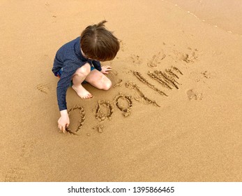 Child Writing Numbers In The Sand On A Beach
