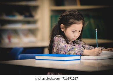 A Child Is Writing On The Book.