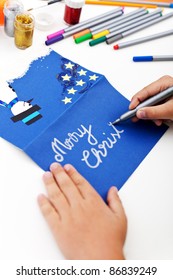 Child Writing On Christmas Greeting Card Made By Hand