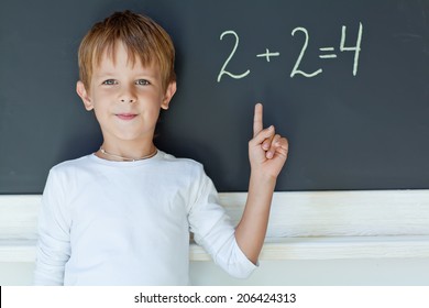 Child Writing Sum On Blackboard