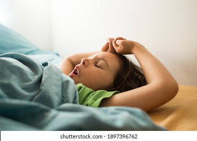 The child yawns while lying in bed, The boy stretches while waking up, Sleepy baby, The boy falls asleep, Morning Awakening.
