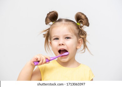 Child In A Yellow T-shirt With Clean Teeth Brushing On A Light Background