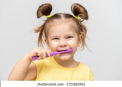 Child In A Yellow T-shirt With Clean Teeth Brushing On A Light Background