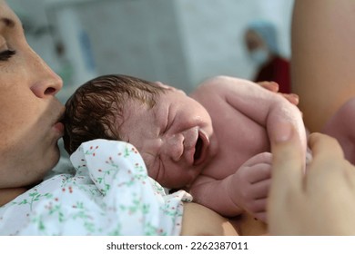 childbirth. Mother and newborn. The birth of a child in a maternity hospital. A young mother hugs her newborn baby after giving birth. Childbirth woman. The first moments of a child's life after child - Shutterstock ID 2262387011