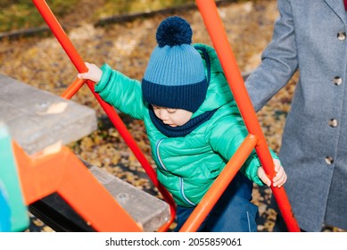Childhood, active recreation for children on playground. Close-up of child climbing steps up slide, outdoor.