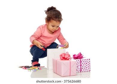 Childhood, Birthday, Party, Holidays And People Concept - Happy Little African American Baby Girl With Gift Boxes Playing With Confetti And Shopping Bag