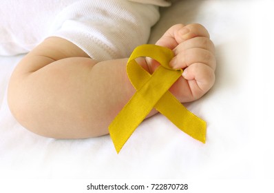 Childhood cancer awareness gold ribbon on human hand and baby background.Gold ribbon symbolic concept raising campaign support help childhood cancer awareness, - Shutterstock ID 722870728
