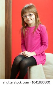 Childhood, Childcare, Being Polite Concept. Little Toddler Girl Wearing Eyeglasses Sitting On Sofa