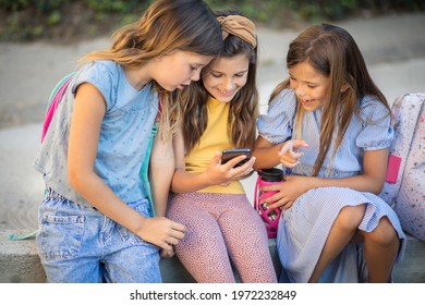 Childhood in the digital age. Three little girls playing outside.
