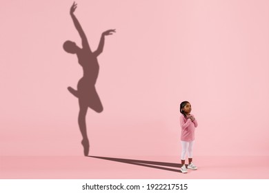 Childhood and dream about big and famous future. Conceptual image with girl and drawned shadow of female ballet dancer on coral pink background. Childhood, dreams, imagination, education concept. - Shutterstock ID 1922217515