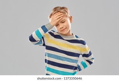 childhood, expressions and people concept - sick little boy in red polo t-shirt suffering from headache over grey background - Powered by Shutterstock