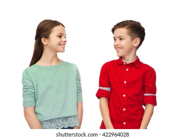 childhood, fashion and people concept - happy smiling boy and girl looking at each other