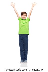 childhood, fashion, power, joy and people concept - happy smiling boy in green polo t-shirt raising hands up