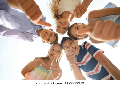 childhood, friendship and gesture concept - group of smiling happy children showing thumbs up in circle - Shutterstock ID 1173379270