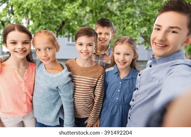 Childhood, Friendship, Technology And People Concept - Happy Children Talking Selfie Over Private House Backyard Background