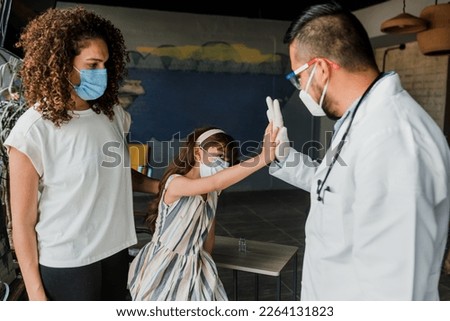 Childhood girl vaccination, hispanic young doctor vaccinating little girl at home. Vaccine for covid-19 coronavirus, flu, infectious diseases in Mexico Latin America