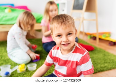 Konzept der Kindheit, Freizeit und Menschen - süßer kleiner Junge über Kindern, der mit Modellierton spielt oder daheim schlank