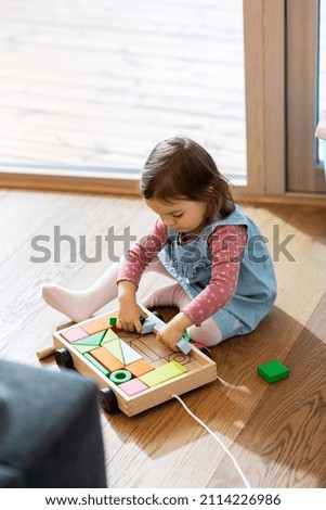 Image, Stock Photo A baby girl is spoon fed with yogurt by her mother