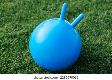 childhood, leisure and toys concept - close up of red bouncing ball or hoppers on grass - Shutterstock ID 2292690015