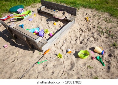 Childhood. Old Sandpit Sandbox With Colorful Plastic Toys On The Playground Or In The Garden. Outdoor. Play.